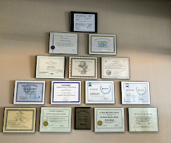 Wall of continuing education and credential certificates at Serene Dental